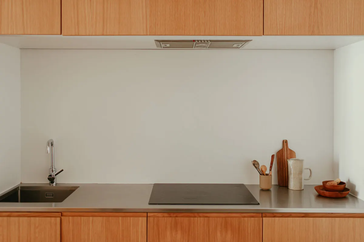 Cocina de frente recto con encimera de madera, placa de inducción y fregadero bajo la ventana