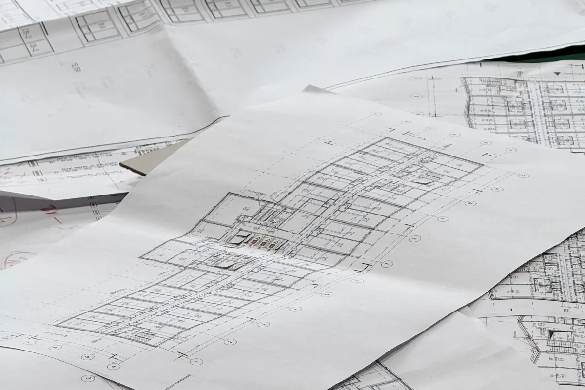 Planos de arquitectura apilados sobre una mesa